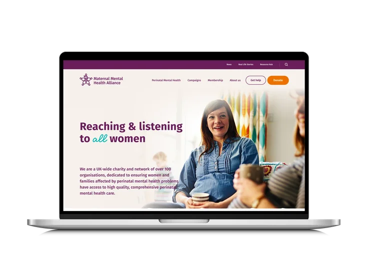 A laptop showing the Maternal Mental Health Alliance homepage, with "Reaching & listening to all women" headline and a photo of women talking together.