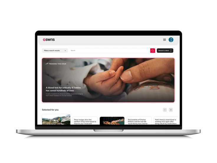 A laptop showing the SWNS newswire homepage, with search filters, a trending story on a critically ill babies blood test, and a "Selected for you" story row.