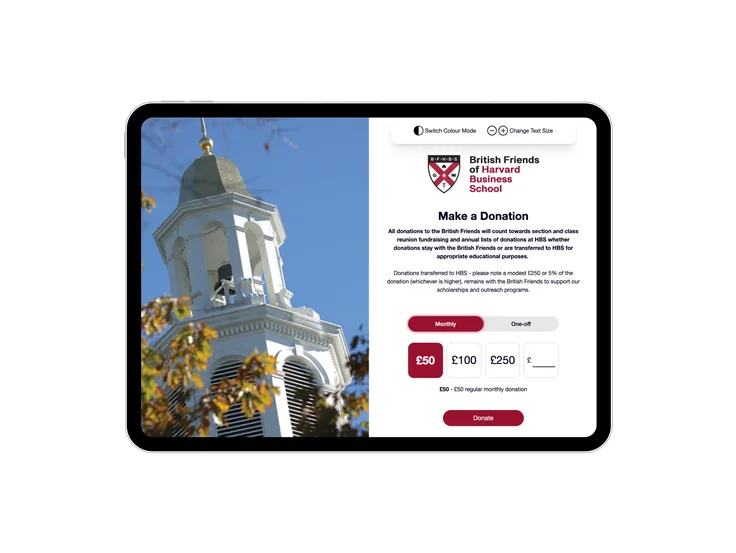 A tablet showing the British Friends of HBS "Make a Donation" page, with monthly and one-off donation options and a photo of a campus bell tower.