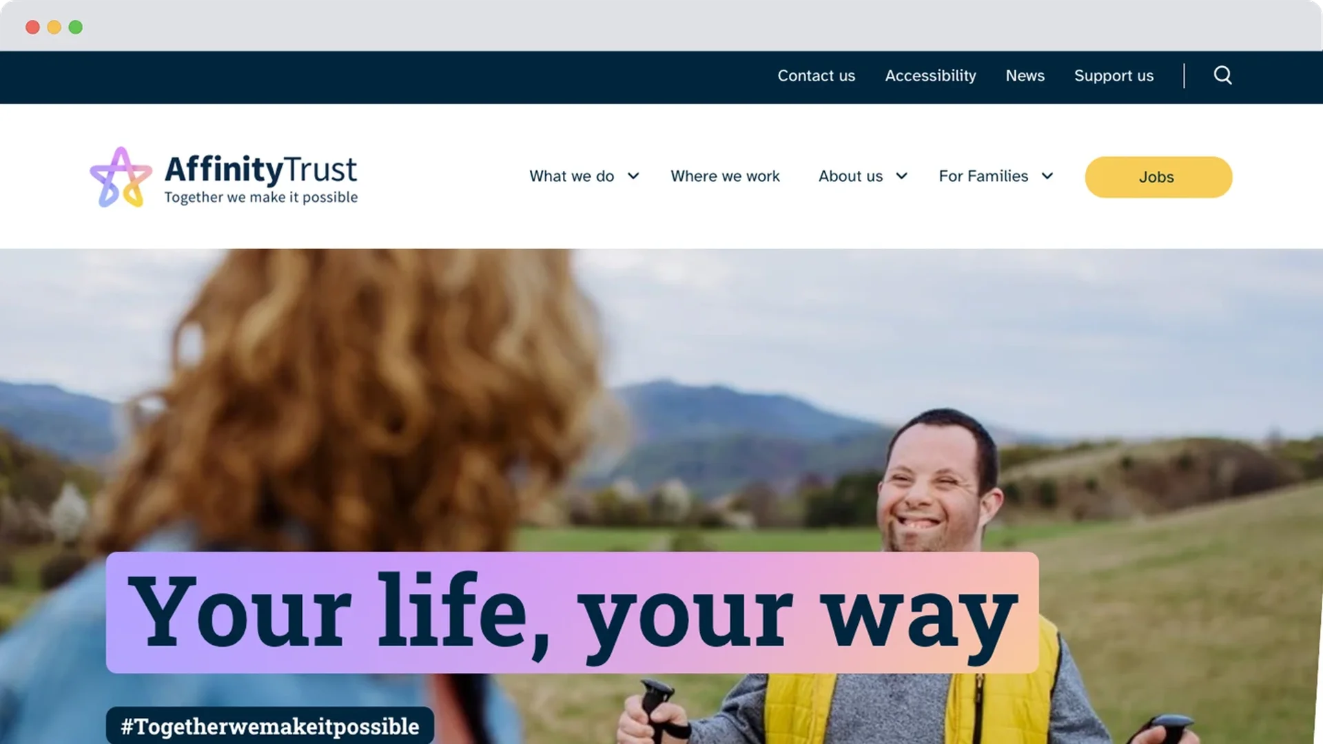 An image showing Affinity Trust's new website design. A man with Down’s syndrome smiles as he walks outdoors using walking poles, looking towards a woman in the foreground. A banner over the image reads: “Your life, your way”.