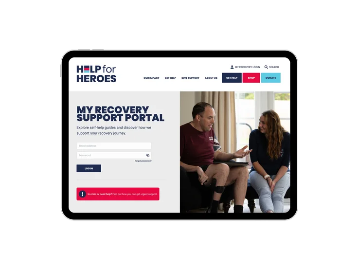 A tablet showing the Help for Heroes My Recovery Support Portal login page, with email and password fields and a photo of a veteran with a prosthetic leg talking to a support worker.